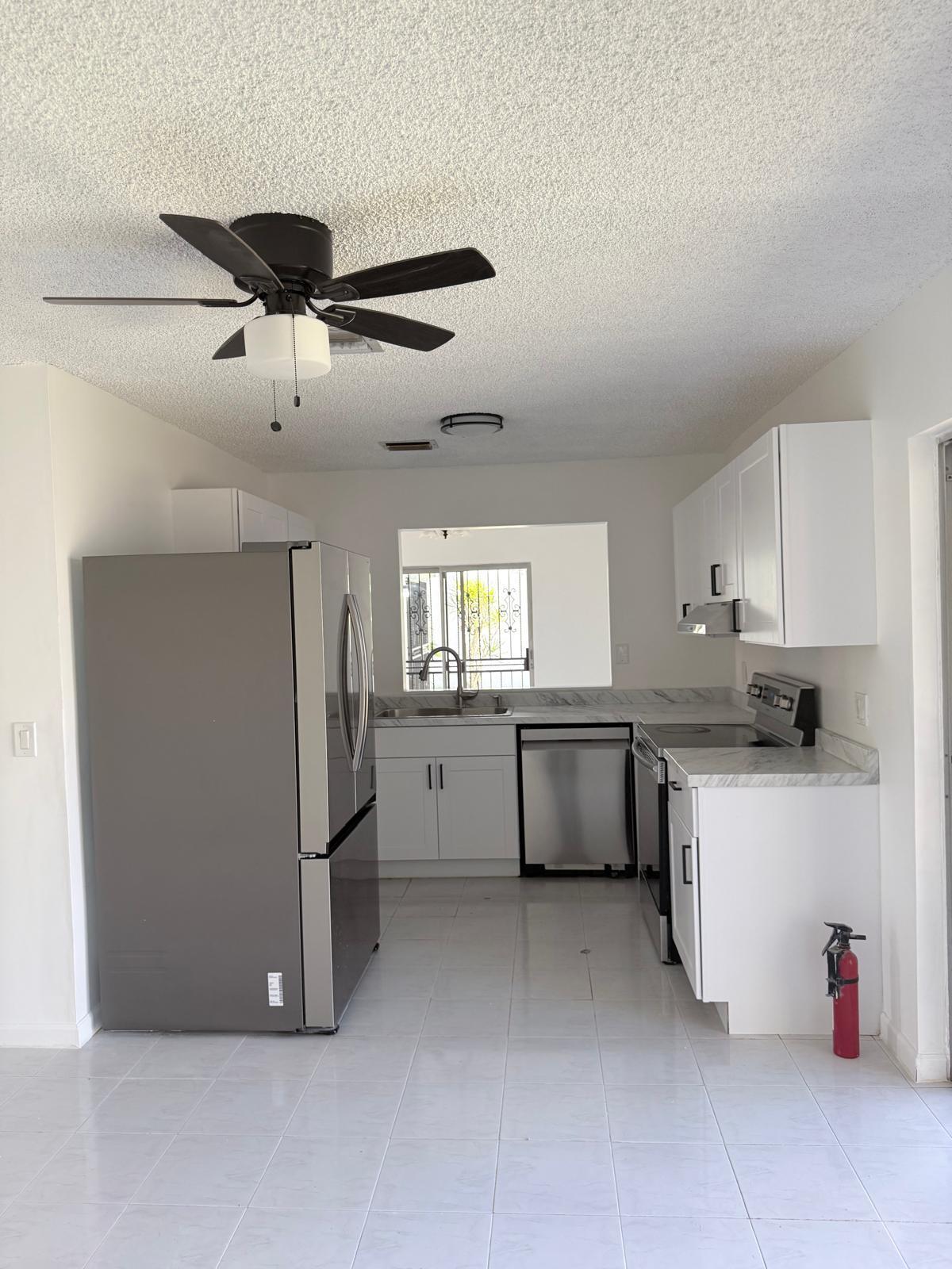 12231 Southwest 210th Street Miami, FL 33177 - Photo 21 of 38 a kitchen with a refrigerator and white cabinets