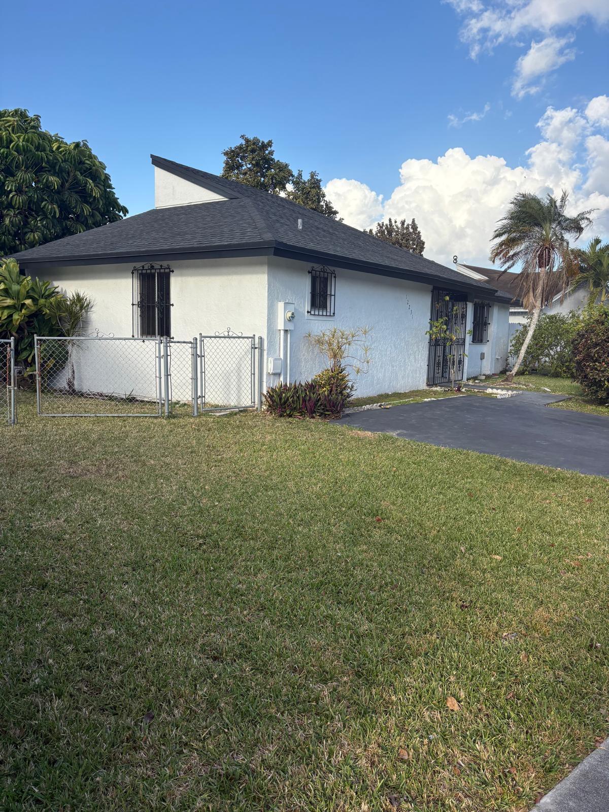 12231 Southwest 210th Street Miami, FL 33177 - Photo 4 of 38 a house view with a garden space