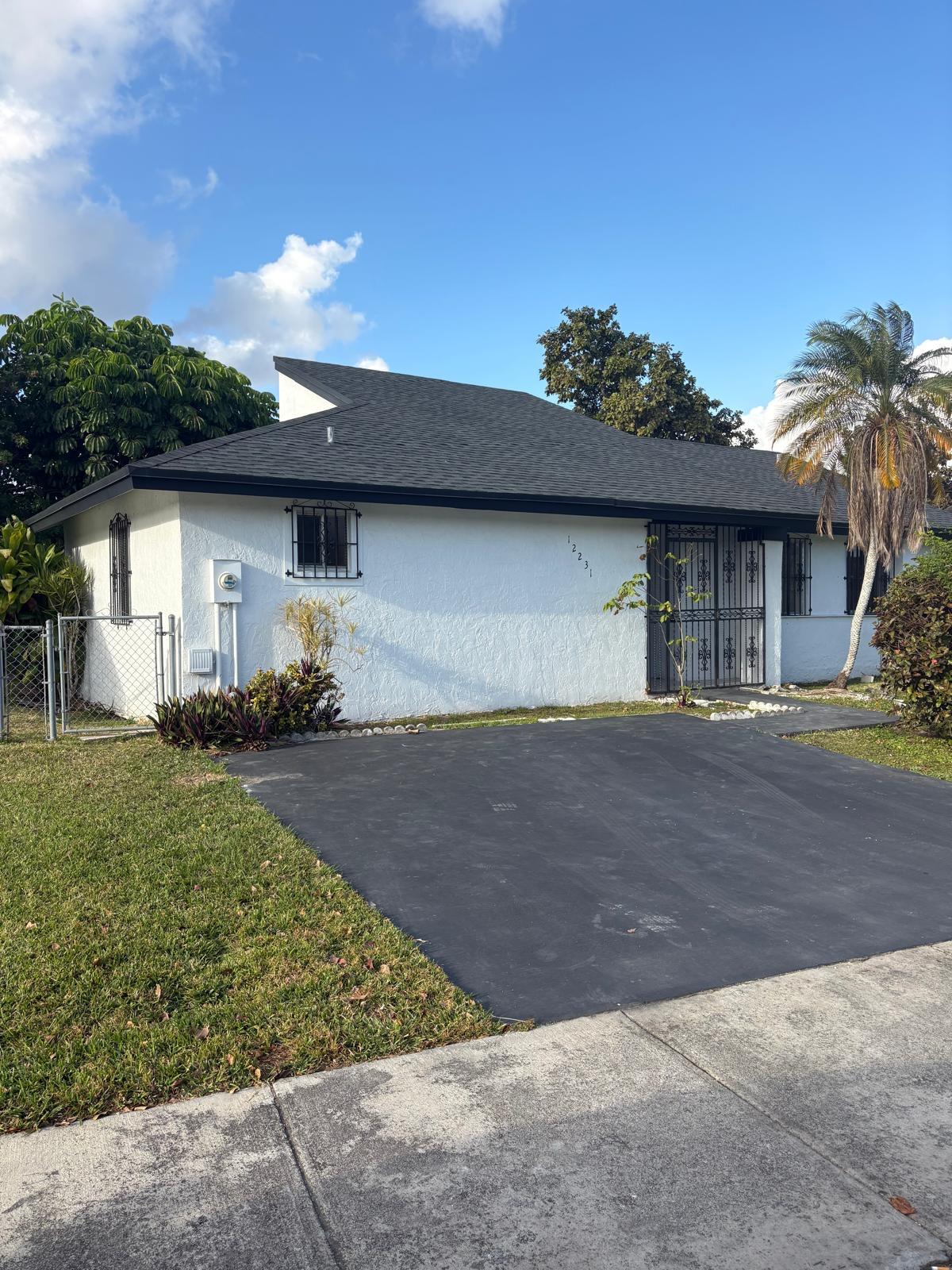 12231 Southwest 210th Street Miami, FL 33177 - Photo 5 of 38 a front view of a house with a yard and a garage