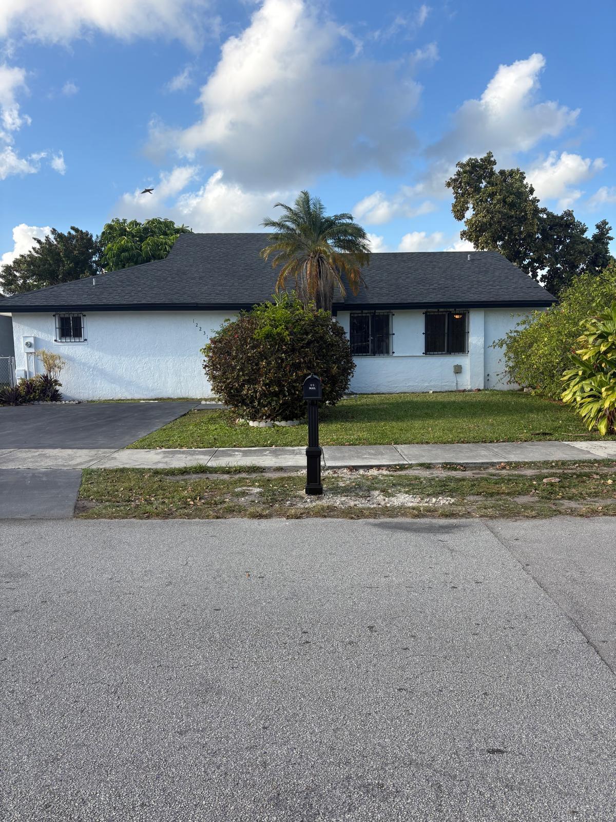12231 Southwest 210th Street Miami, FL 33177 - Photo 6 of 38 a front view of a house with a yard and garage