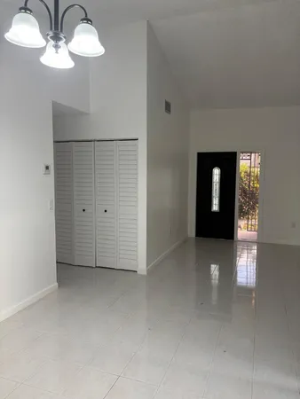 an empty room with chandelier fan