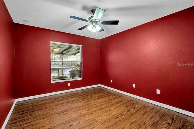 an empty room with windows and fan