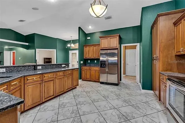 a large kitchen with stainless steel appliances a refrigerator and a sink