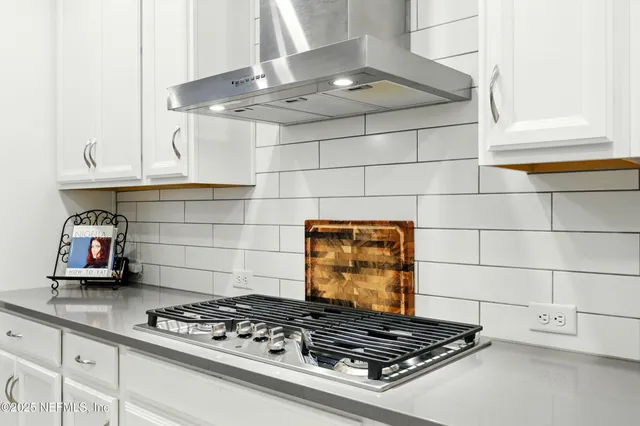 a kitchen with granite countertop a stove and cabinets