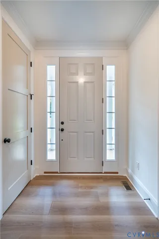 a view of empty room with window and wooden floor