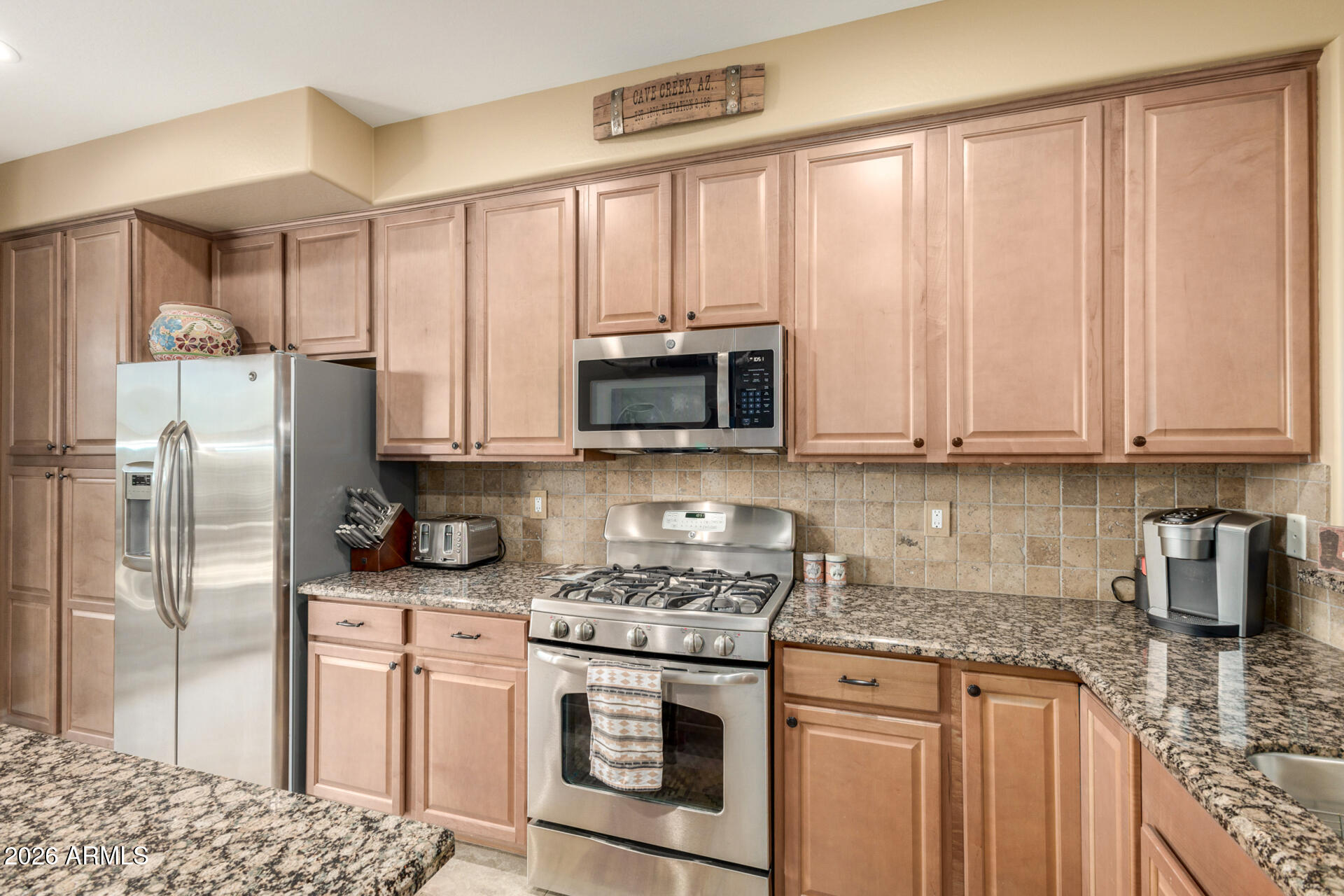 6434 East Military Road, Unit 102 Cave Creek, AZ 85331 - Photo 14 of 66 a kitchen with stainless steel appliances granite countertop a stove a refrigerator and a white cabinets