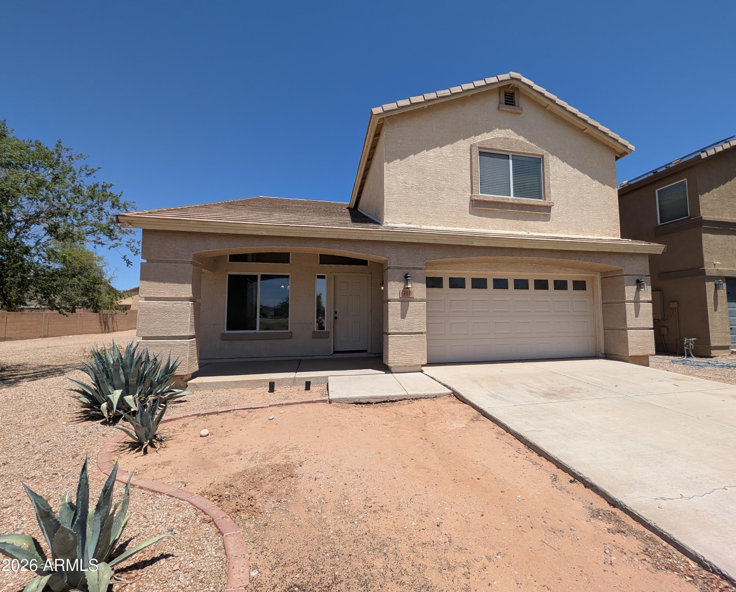712 Baldwin Loop Coolidge, AZ 85128 - Photo 1 of 21 a front view of a house with a yard
