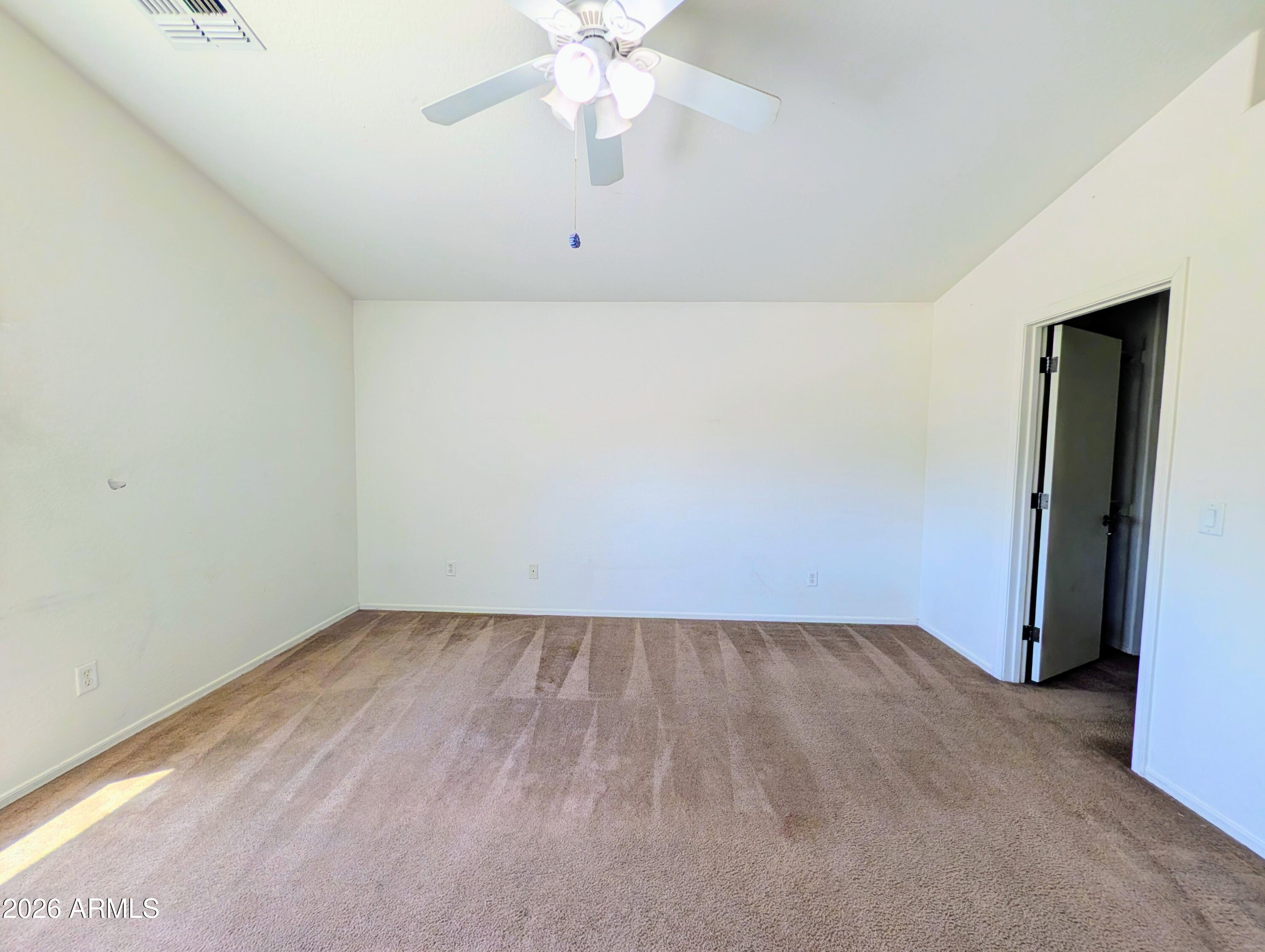 712 Baldwin Loop Coolidge, AZ 85128 - Photo 13 of 21 an empty room with a ceiling fan and carpet