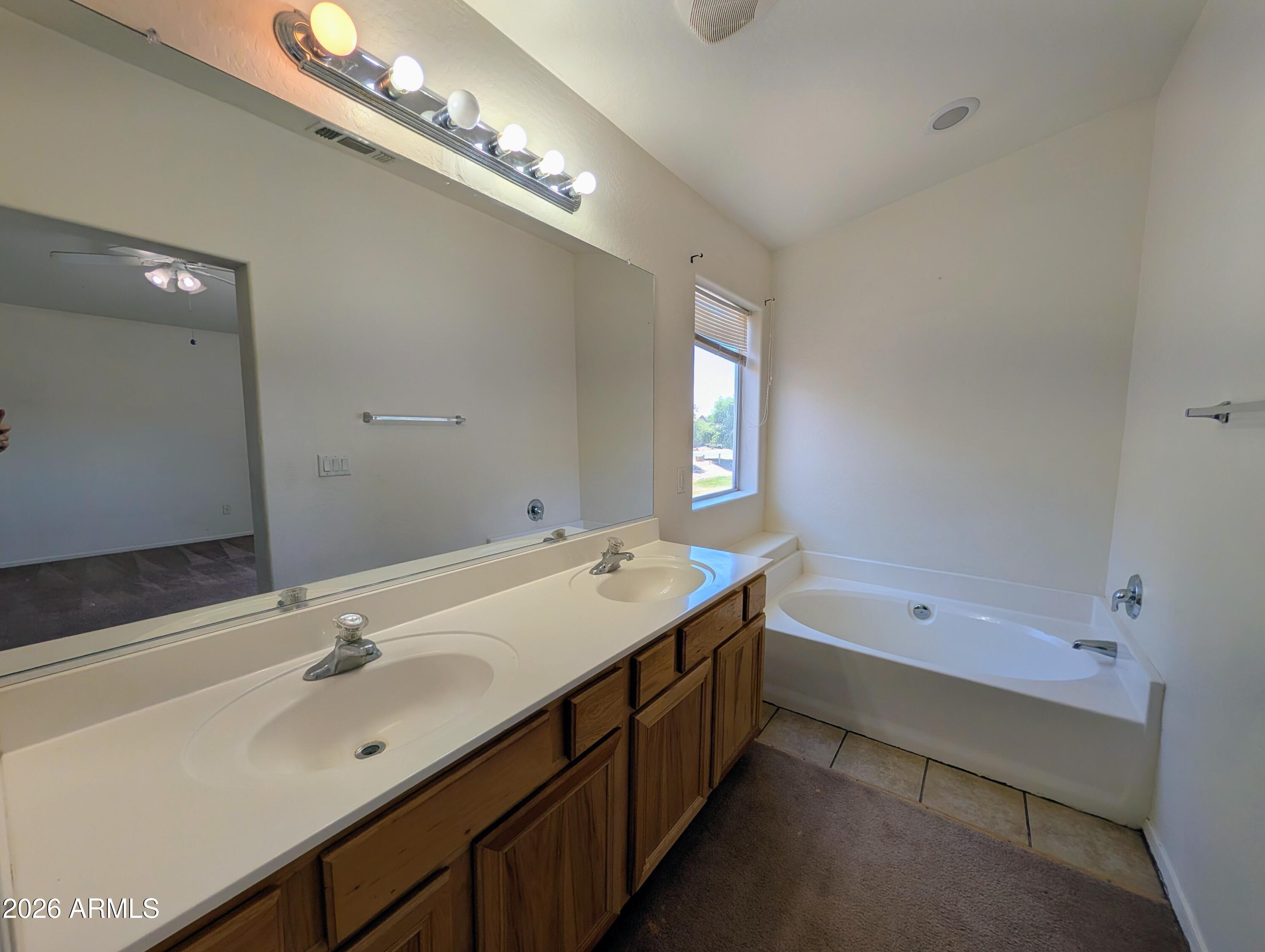 712 Baldwin Loop Coolidge, AZ 85128 - Photo 15 of 21 a bathroom with a tub double sink and mirror