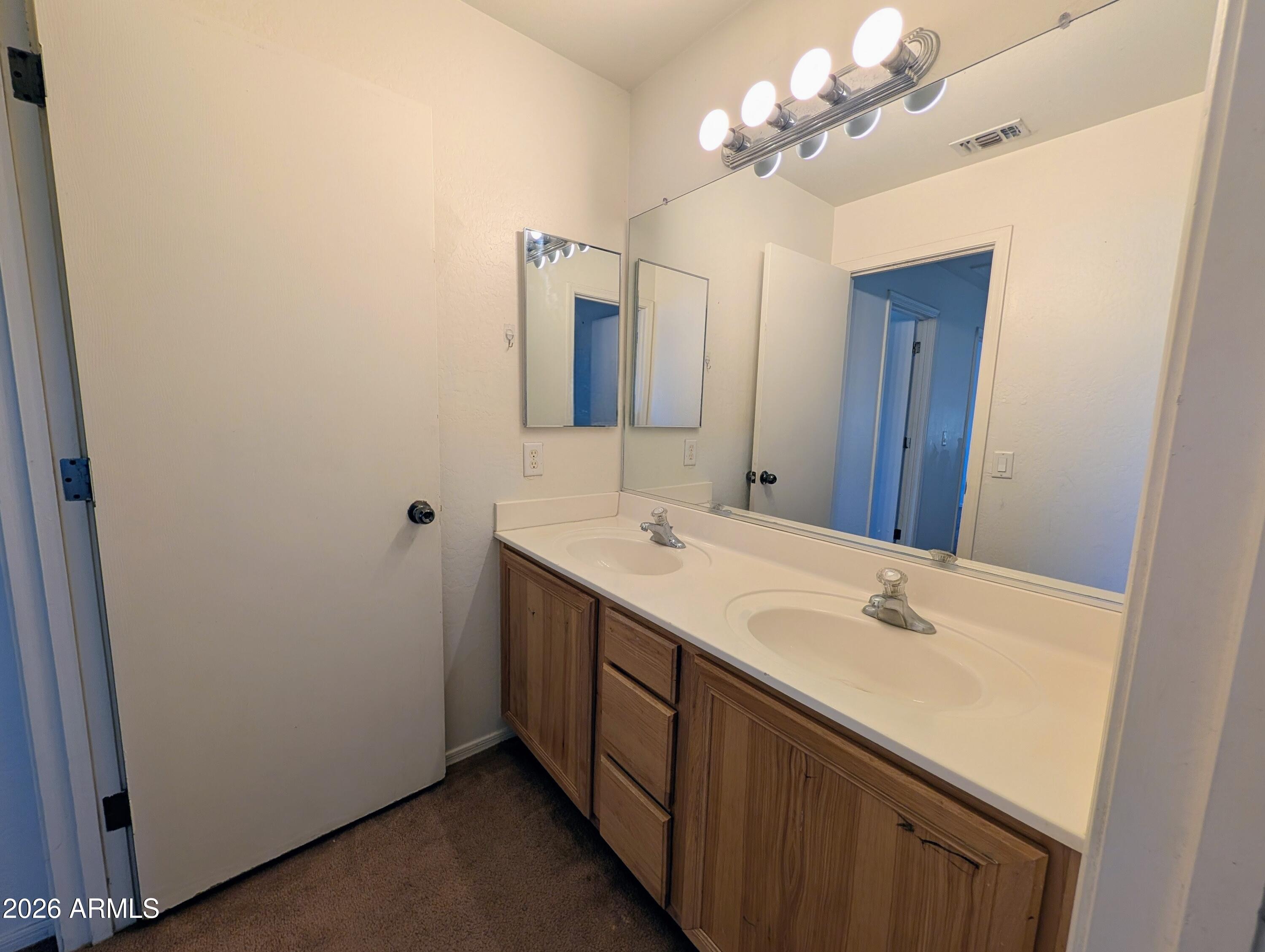 712 Baldwin Loop Coolidge, AZ 85128 - Photo 18 of 21 a bathroom with a sink vanity and a mirror