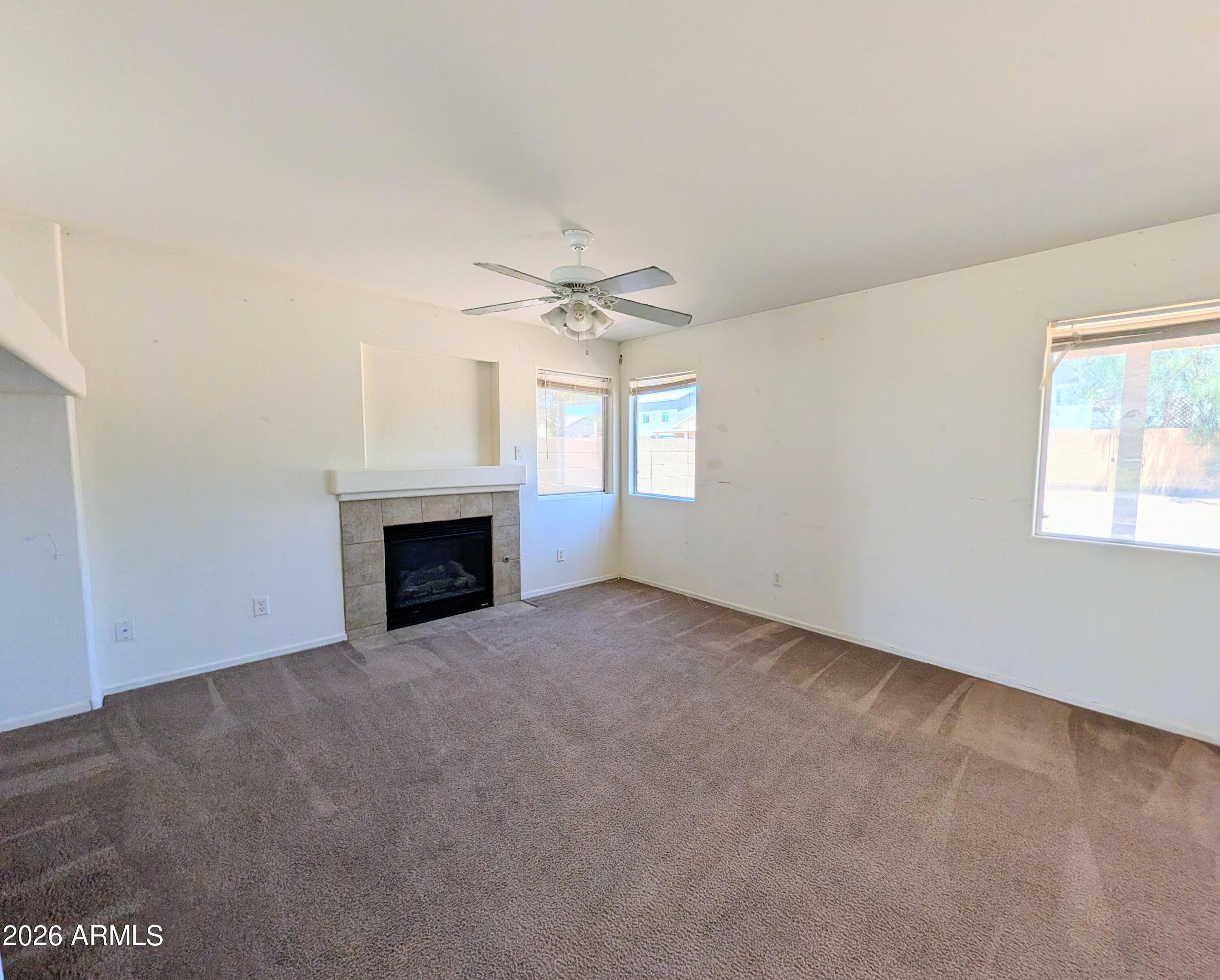 712 Baldwin Loop Coolidge, AZ 85128 - Photo 4 of 21 an empty room with windows and fireplace