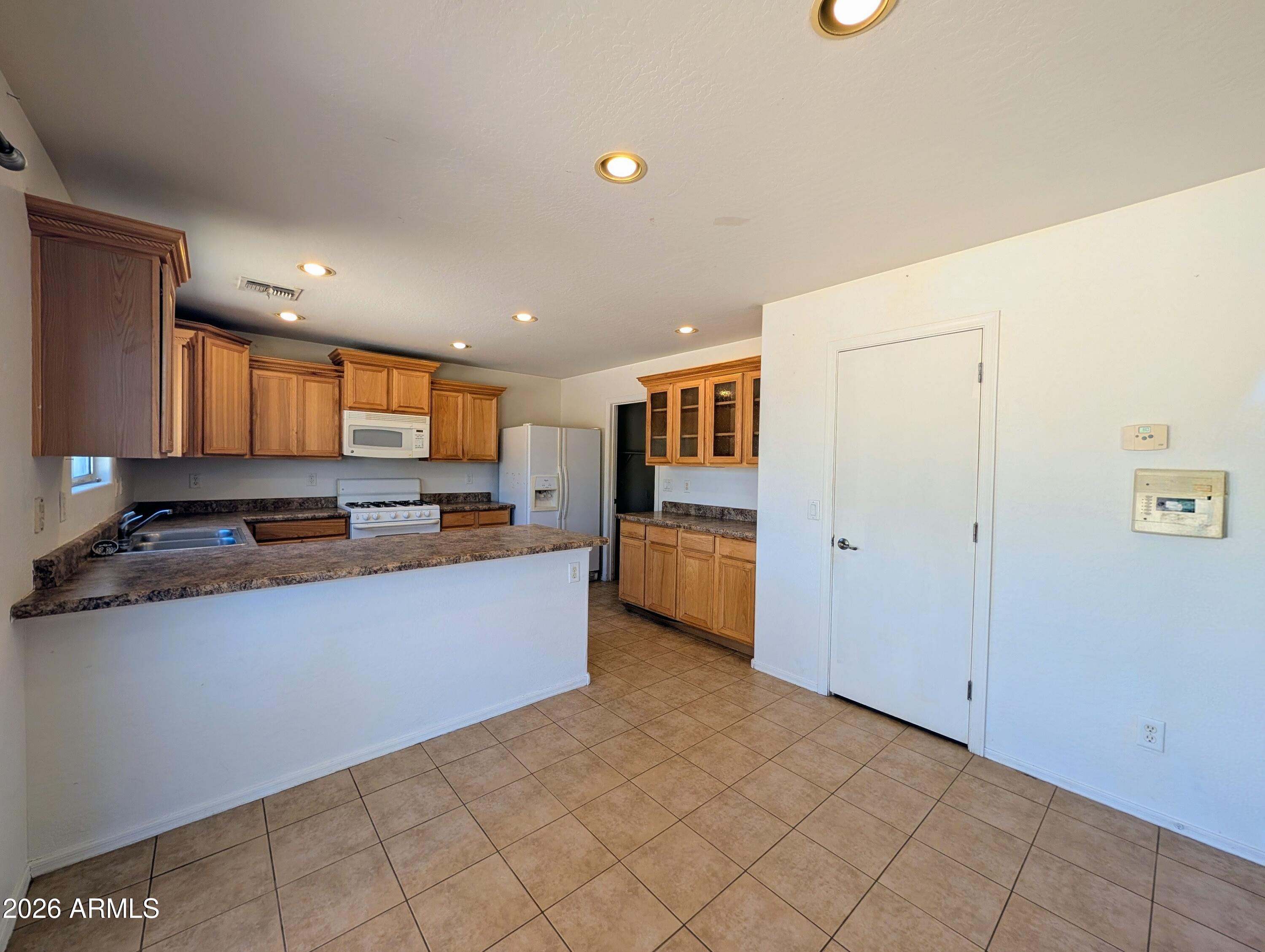 712 Baldwin Loop Coolidge, AZ 85128 - Photo 6 of 21 a kitchen with stainless steel appliances a refrigerator and a stove top oven