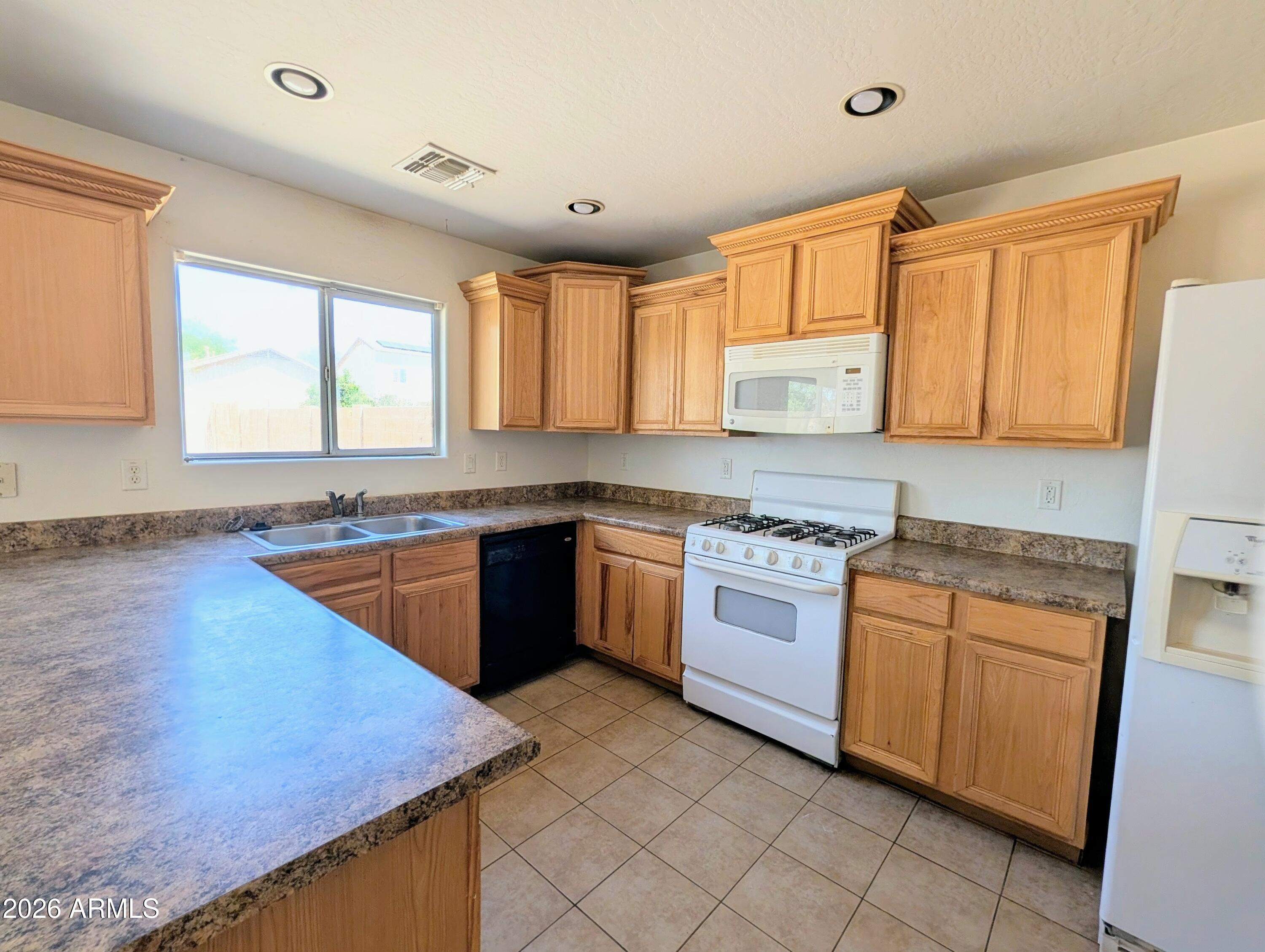 712 Baldwin Loop Coolidge, AZ 85128 - Photo 7 of 21 a kitchen with stainless steel appliances granite countertop a stove a sink and a microwave