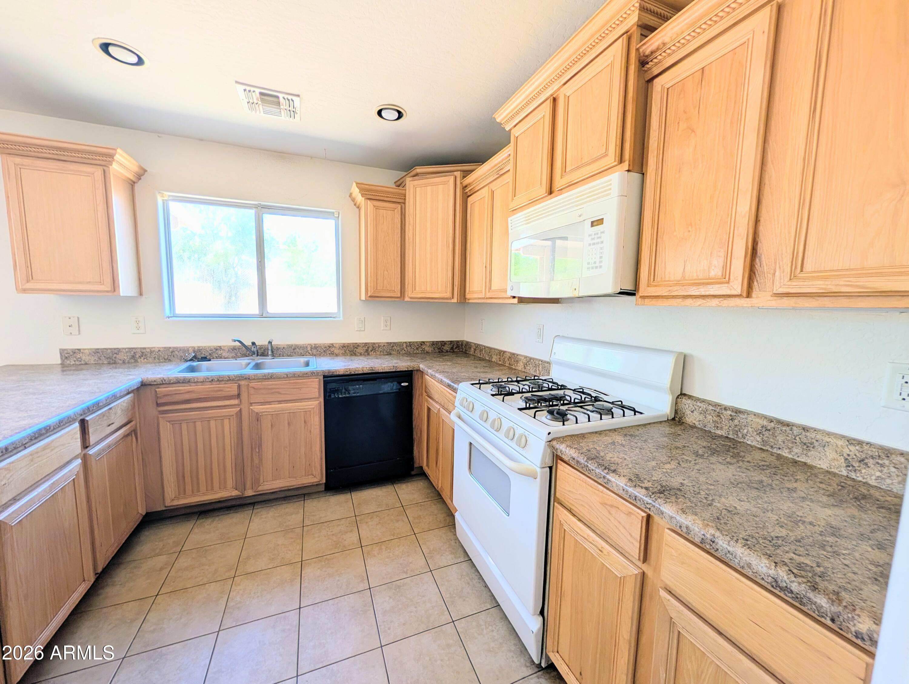 712 Baldwin Loop Coolidge, AZ 85128 - Photo 8 of 21 a kitchen with stainless steel appliances granite countertop a stove a sink and a microwave