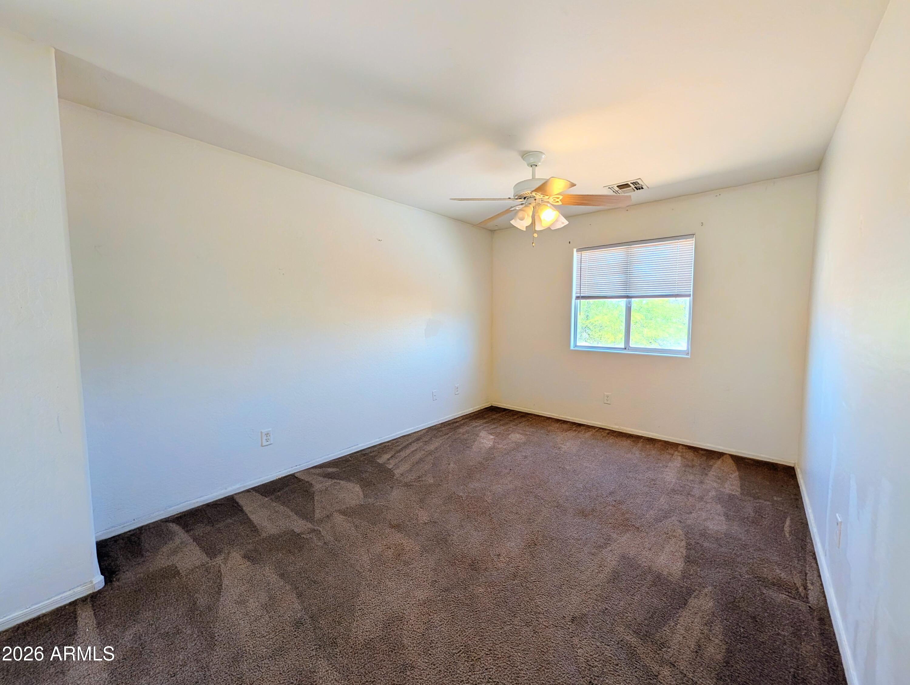 712 Baldwin Loop Coolidge, AZ 85128 - Photo 9 of 21 an empty room with windows and chandelier fan