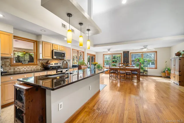 a kitchen with stainless steel appliances granite countertop sink stove top oven and cabinets