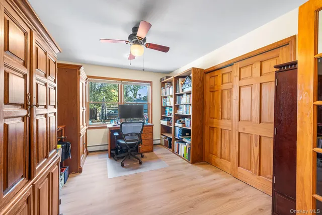 a view of a workspace with furniture and a window