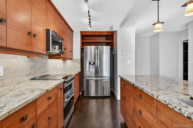 a kitchen with stainless steel appliances granite countertop a sink and a refrigerator
