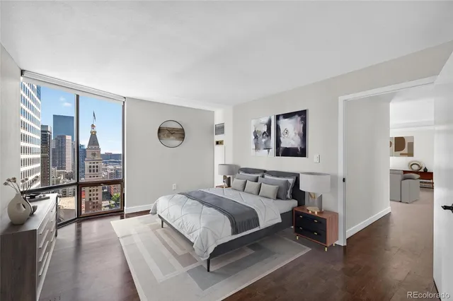 a spacious bedroom with a bed and a lamp on table