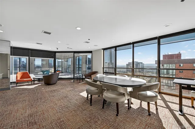 a dining room with furniture and a floor to ceiling window
