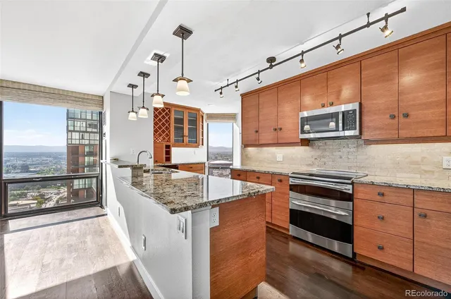a kitchen with stainless steel appliances granite countertop a sink stove and microwave