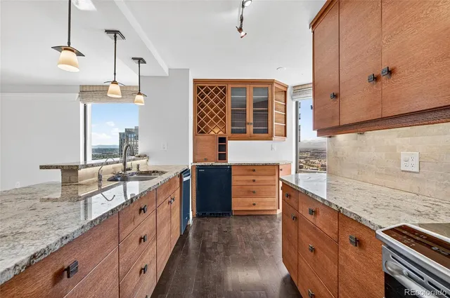 a kitchen with granite countertop a stove a sink and a refrigerator