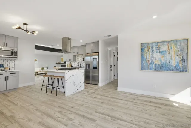 a large kitchen with cabinets wooden floor and stainless steel appliances