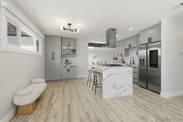 a kitchen with stainless steel appliances a refrigerator sink and wooden floor