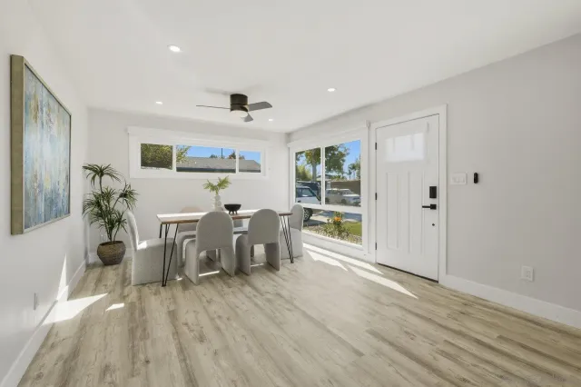 a living room with furniture a dining table and a potted plant