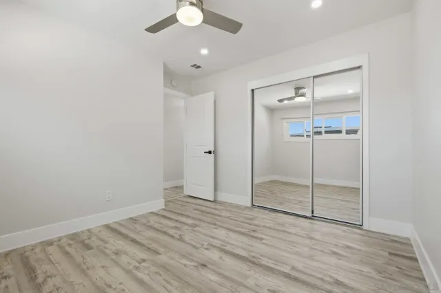 an empty room with closet and a chandelier fan