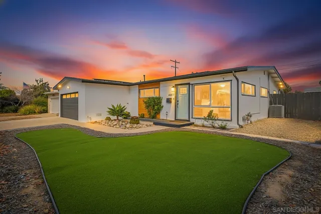 a view of a house with backyard and sitting area
