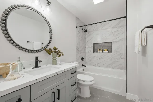 a bathroom with a granite countertop sink a toilet and a mirror