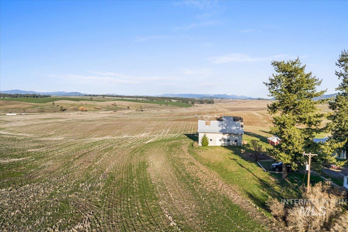 Expansive agricultural landscape featuring rolling fields and distant hills