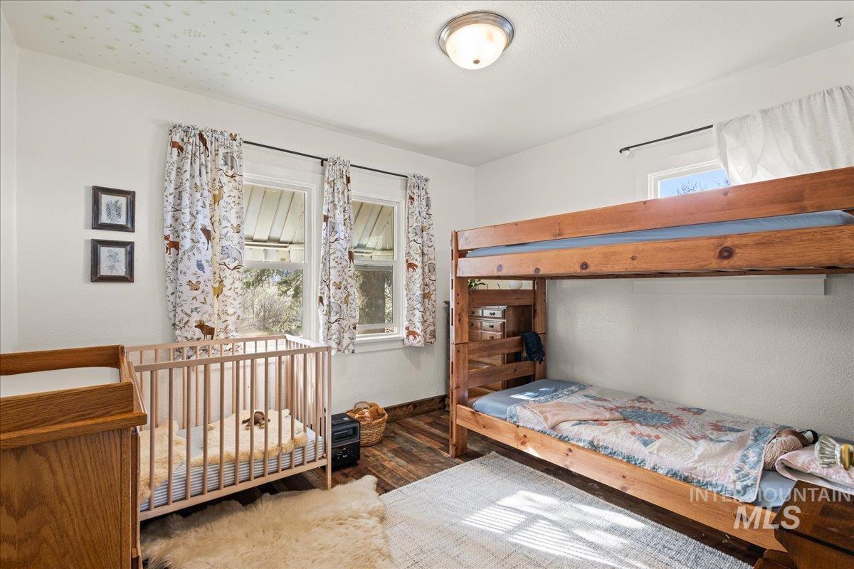 19454 Idaho Road Worley, ID 83876 - Photo 22 of 39 Bright room featuring a wood-finish bunk bed, wood-finish flooring, two large windows, and a ceiling-mounted light fixture