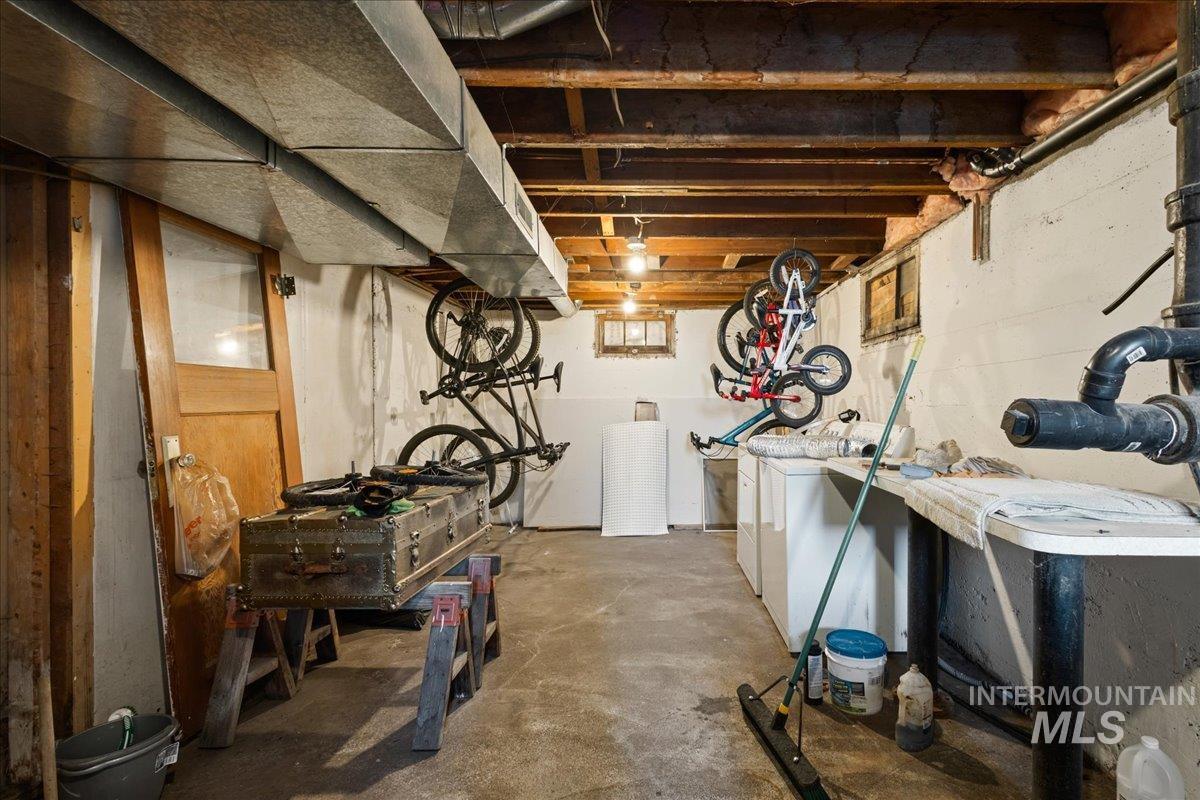 19454 Idaho Road Worley, ID 83876 - Photo 24 of 39 Basement utility area featuring exposed wood beam ceiling, concrete flooring, and exposed ductwork