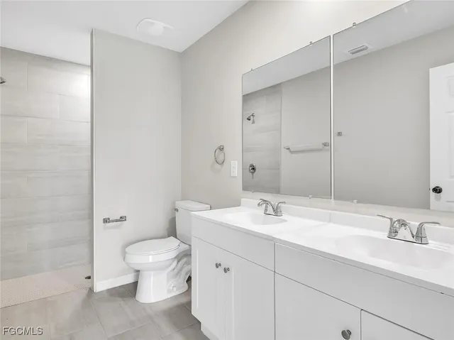 a bathroom with a double vanity sink toilet and a mirror