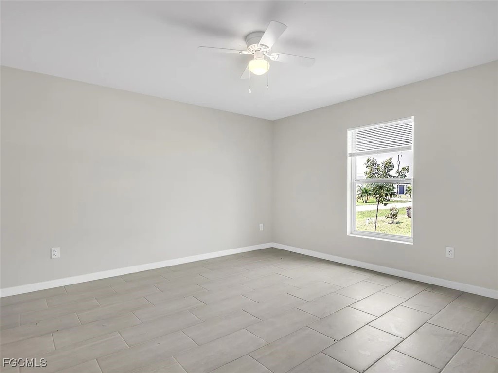 4622 Southwest 8th Court Cape Coral, FL 33914 - Photo 7 of 8 an empty room with windows and fan