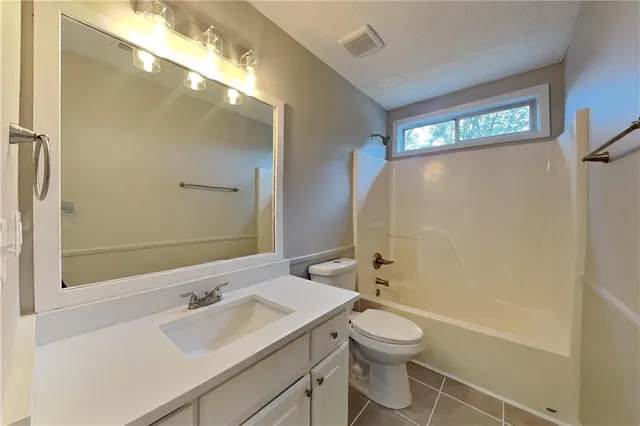 a bathroom with a granite countertop sink toilet a large mirror and shower