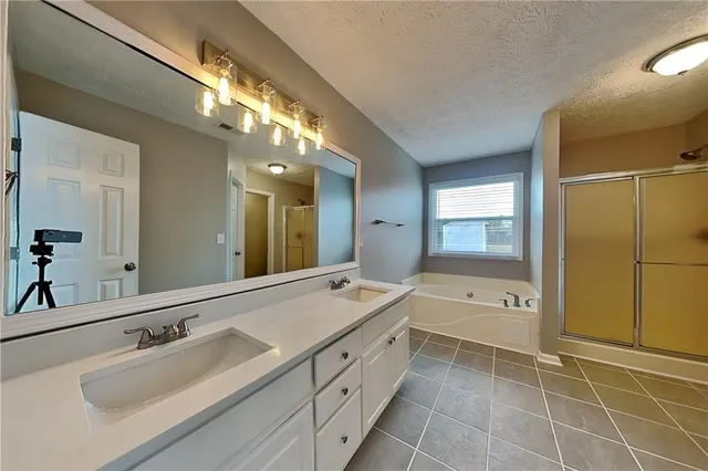 a spacious bathroom with a tub sink and mirror