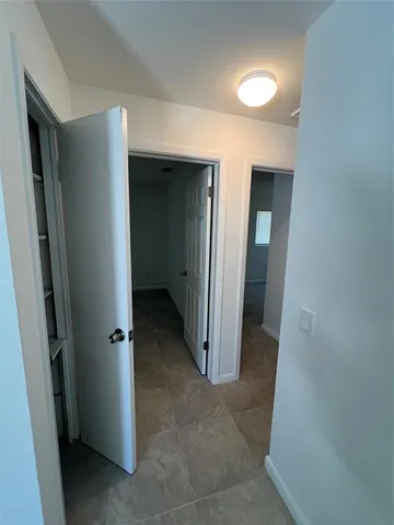 a view of a hallway with wooden shelves