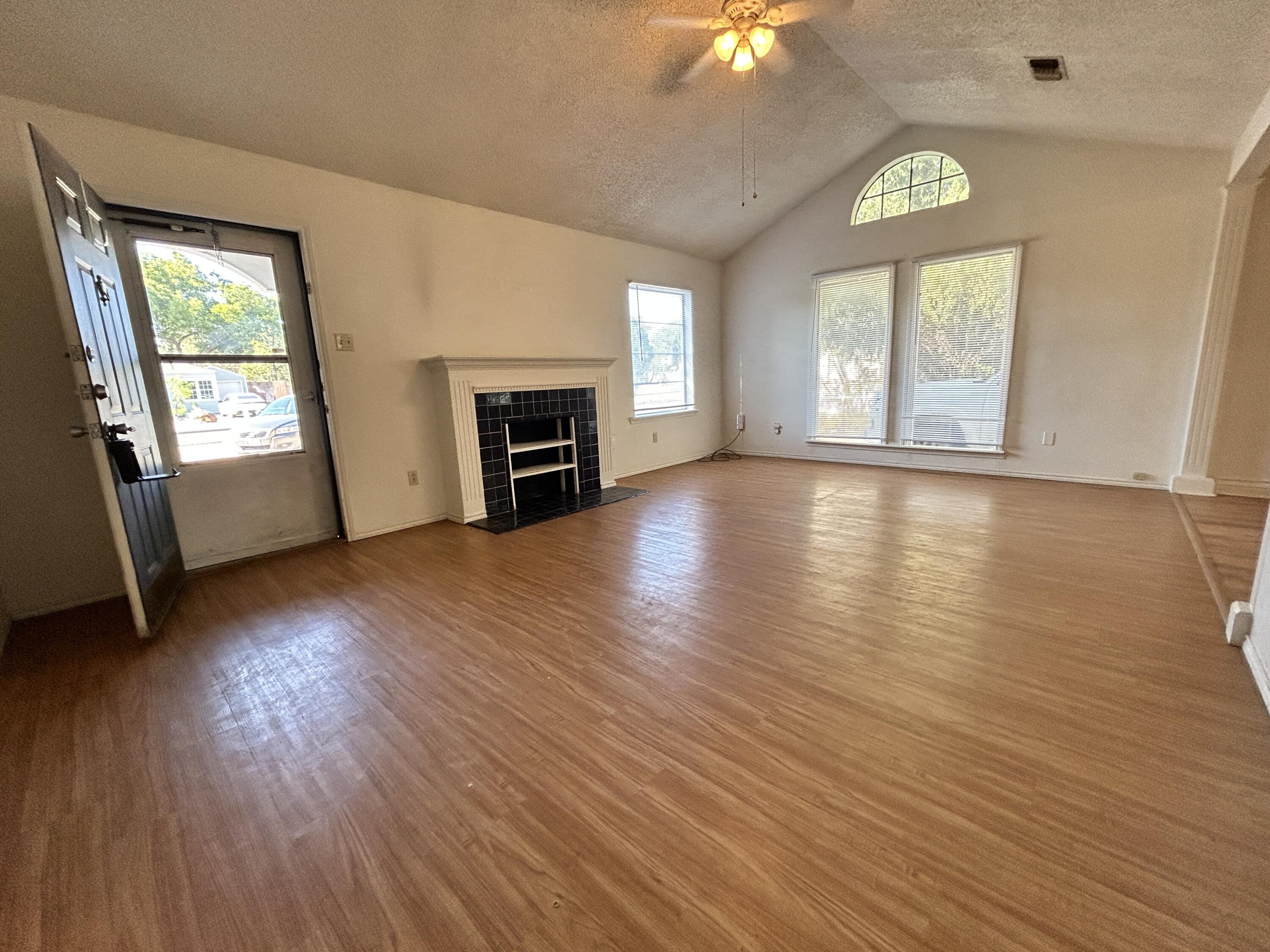 2216 30th Street, Unit FRONT Lubbock, TX 79411 - Photo 2 of 11 an empty room with windows fireplace and wooden floor