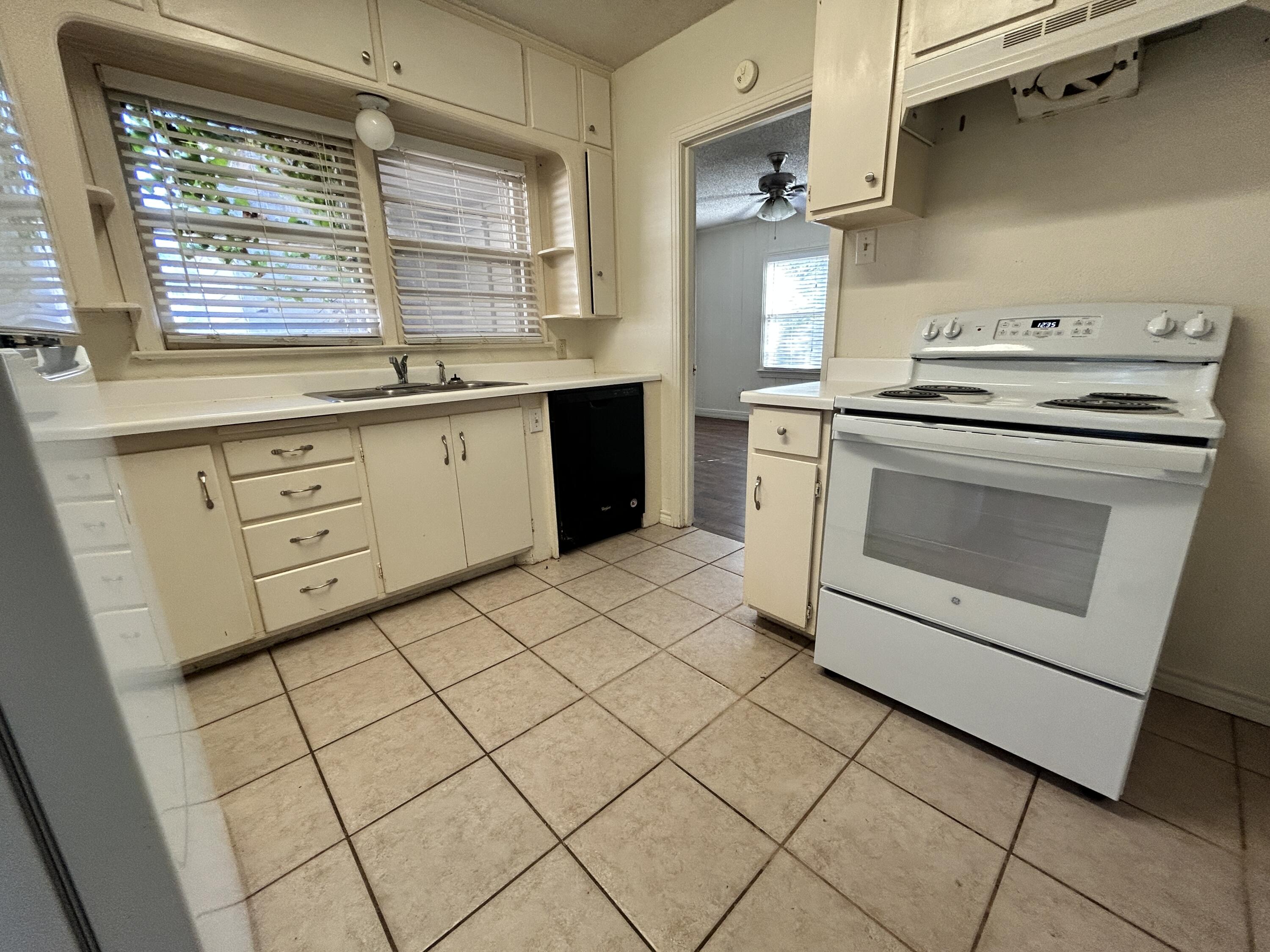 2216 30th Street, Unit FRONT Lubbock, TX 79411 - Photo 3 of 11 a kitchen with a stove cabinets and wooden floor