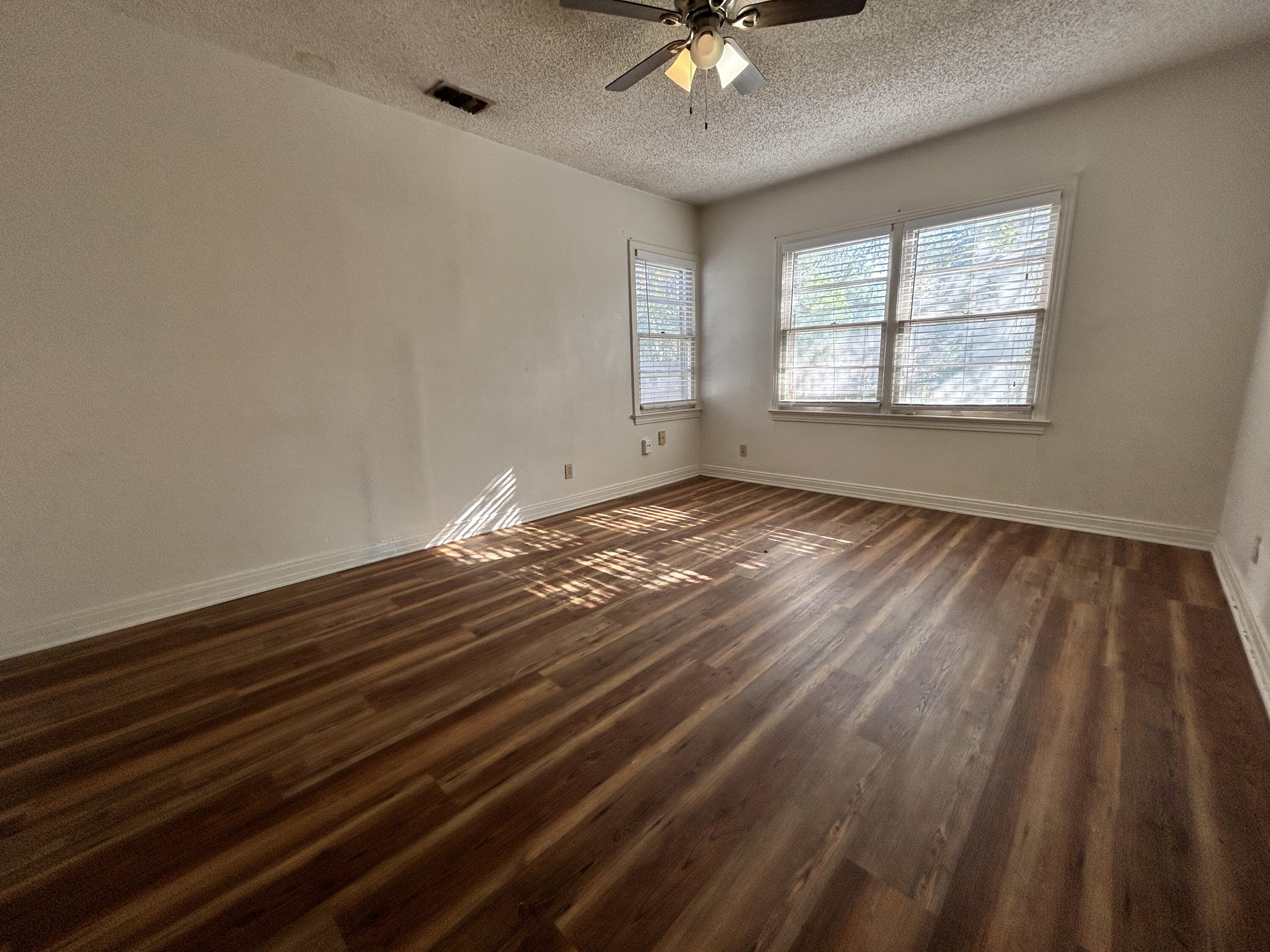 2216 30th Street, Unit FRONT Lubbock, TX 79411 - Photo 5 of 11 a view of an empty room with wooden floor and a window