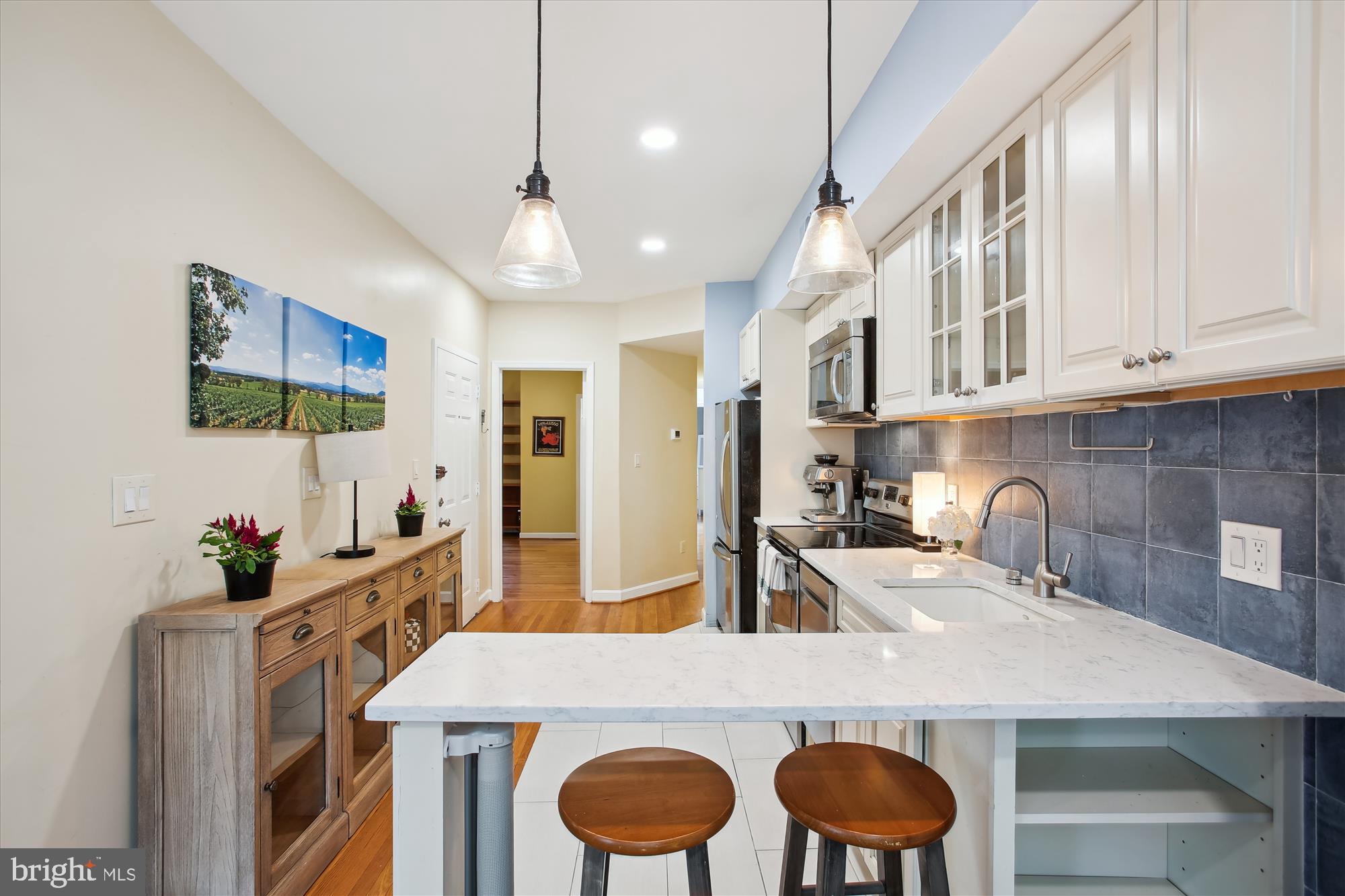 1725 Willard Street Northwest, Unit 3 Washington, DC 20009 - Photo 10 of 32 a kitchen with granite countertop a table chairs stove and cabinets