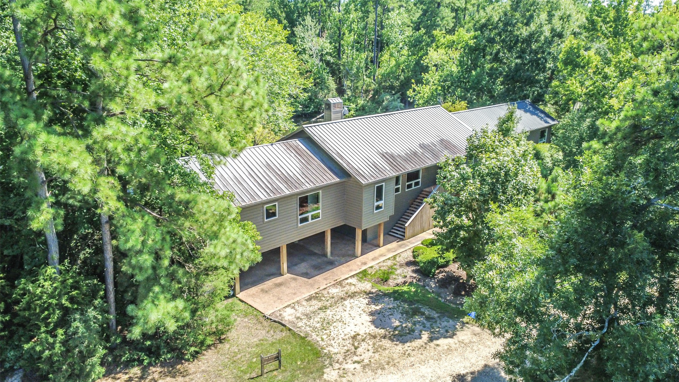 88 Raccoon Ramble Cleveland, TX 77327 - Photo 2 of 43 Nestled among lush trees, this elevated home offers serene privacy and a modern design, featuring spacious under-home parking.