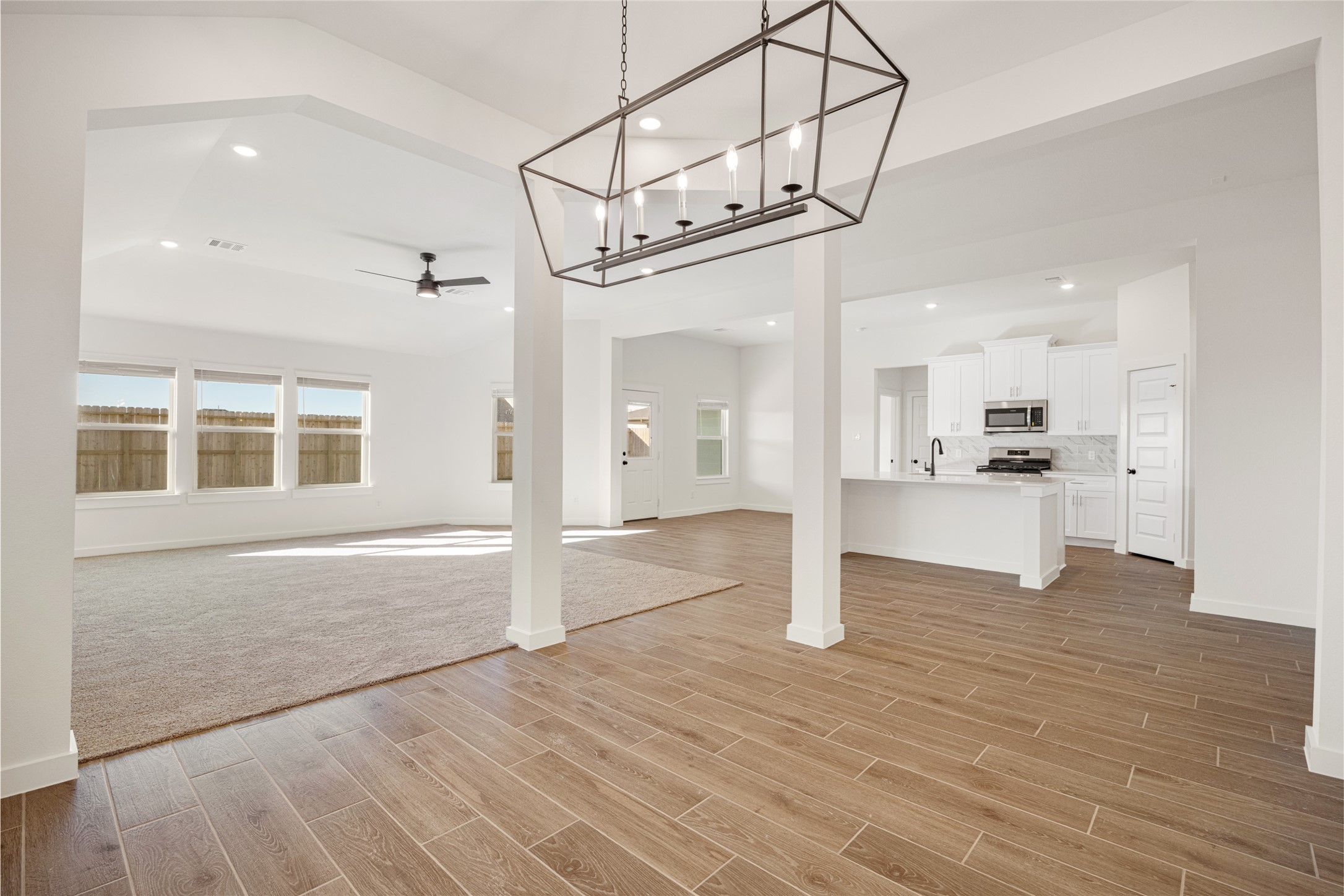 3222 Emerald Hills Drive Angleton, TX 77515 - Photo 5 of 31 a view of an empty room with wooden floor and a kitchen