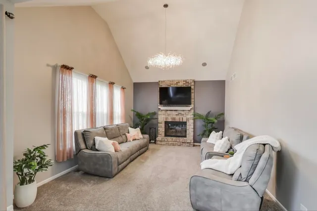 a living room with furniture a fireplace and a potted plant