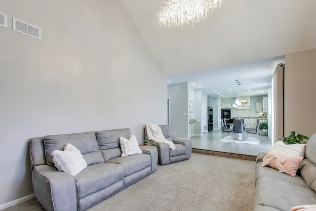 a living room with furniture and a chandelier