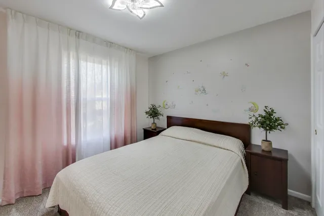 a large bed sitting in a bedroom next to a window