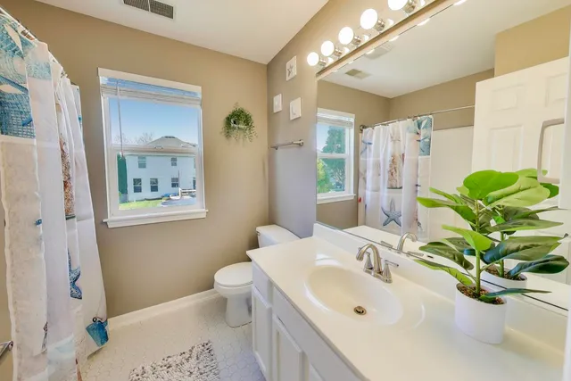 a bathroom with a sink a toilet and a mirror
